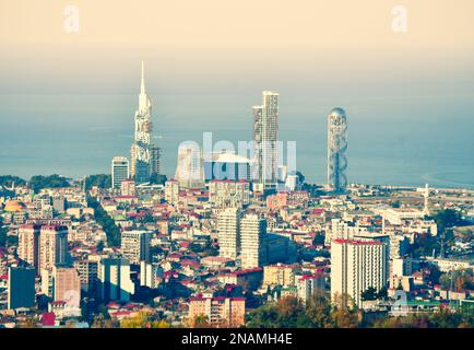 Blick aus der Vogelperspektive auf die Touristenattraktionen der Stadt Batumi und die beeindruckenden Gebäude im Design mit untergehender Sonne im Hintergrund, Reiseziel in Georgi Stockfoto