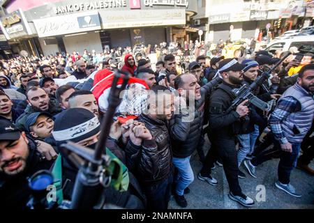 Nablus, Palästina. 13. Februar 2023. (ANMERKUNG DER HERAUSGEBER: Bild zeigt den Tod)Trauernde und Schützen tragen den Körper des 22-jährigen Palästinensers Amir al-Bistami, der von der israelischen Armee während eines Überfalls auf die Stadt Nablus im besetzten Westjordanland erschossen wurde. Die israelische Armee sagte, dass ihre Streitkräfte Nablus stürmten und es geschafft hätten, die beiden gesuchten Männer, Osama al-Taweel und Abdel Kamal Jouri, zu verhaften, die beschuldigt werden, vor vier Monaten einen israelischen Soldaten an einem Kontrollpunkt westlich von Nablus getötet zu haben. (Foto von Nasser Ishtayeh/SOPA Images/Sipa USA) Guthaben: SIPA USA/Alamy Live News Stockfoto