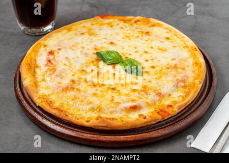 Italienische Pizza mit vier Käsesorten und viel Mozzarella auf einem Schneidebrett Stockfoto