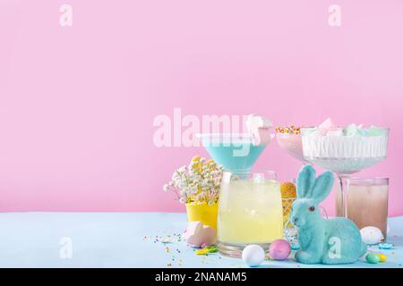Farbenfrohe pastellfarbene Kinder Osterparty Mocktails, cremige und eisgekühlte alkoholfreie Getränke mit Zuckerwatte, Marshmallow, Zuckerstreusel und Osterei Stockfoto