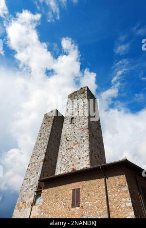 Türme und Häuser auf der Piazza delle Erbe, mittelalterliche Stadt San Gimignano, UNESCO-Weltkulturerbe, Provinz Siena, Toskana, Italien. Stockfoto