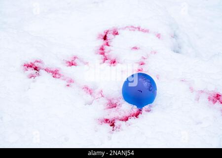 Der Begriff der Symbolik. Kristallkugel auf Schnee mit Blutflecken, selektiver Fokus Stockfoto