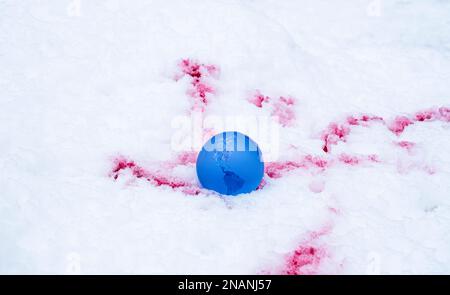 Der Begriff der Symbolik. Kristallkugel auf Schnee mit Blutflecken, selektiver Fokus Stockfoto