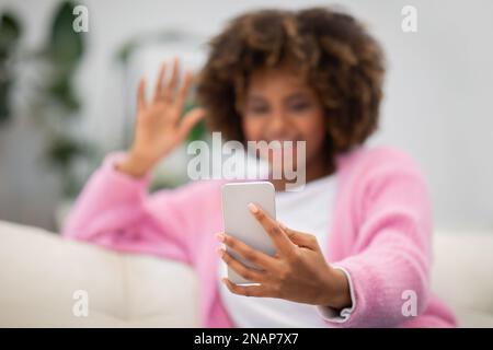 Selektiver Fokus auf das Handy in der Hand einer schwarzen Frau Stockfoto