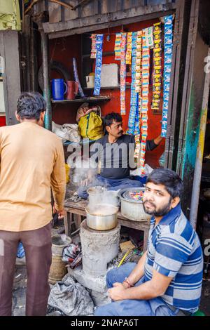 Einheimischer männlicher Stallhalter in einem kleinen Kiosk am Straßenrand, der Street Food in Fariapukur, Shyam Bazar, Kalkutta, Westbengalen, Indien zubereitet Stockfoto