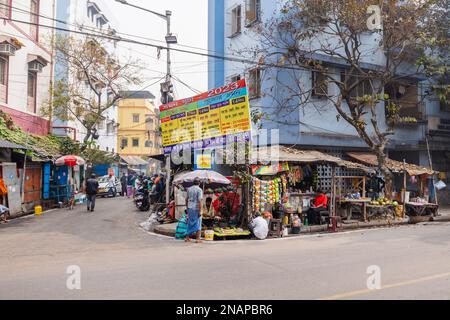 Straßenszene mit lokalen Geschäften und Verkaufsständen am Straßenrand in Fariapukur, Shyam Bazar, Kalkutta, Westbengalen, Indien Stockfoto