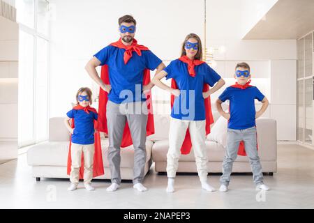 Porträt einer Familie, die vorgibt, im Wohnzimmer zu Hause Superhelden zu sein Stockfoto