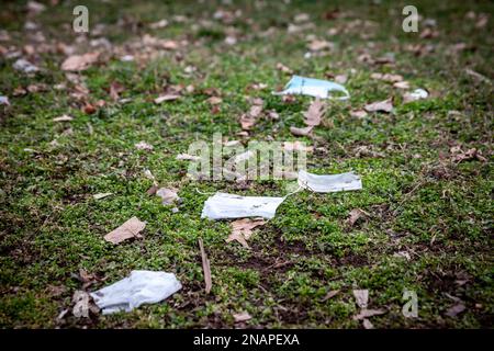 Bild einer alten Einweg-Gesichtsmasken auf dem Boden, im Freien, während der Coronavirus-Krise Stockfoto