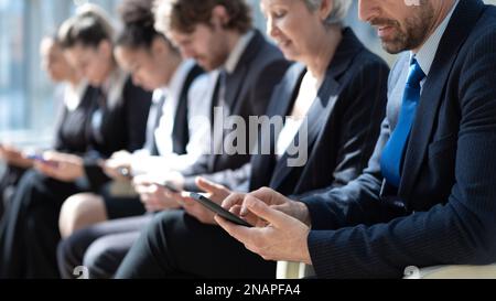 Gruppe von Geschäftsleuten mit Smartphones in einer Reihe Stockfoto