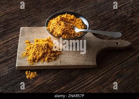 Currypulver (Kurkuma) im Becher – Nahaufnahme. Indische Mischung aus fein gemahlenen Gewürzen Stockfoto