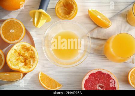 Frisch zubereiteter Saft, Orangen und Reibahle auf Holztisch, flach liegend Stockfoto