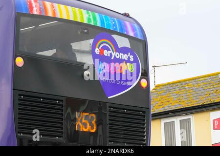 Lyme Regis, Dorset, Großbritannien. 13. Februar 2023 Ein erster Doppeldeckerbus Bus X53 Jurassic Coaster in LGBTQ+ Pride-Farben mit dem Slogan We're Bursting with Pride” and everyone's Welcome on Board” im Lyme Regis in Dorset Picture Credit: Graham Hunt/Alamy Live News Stockfoto