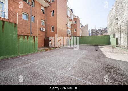 Ein städtischer Tennisplatz in einem Blockhof zwischen Gebäuden Stockfoto