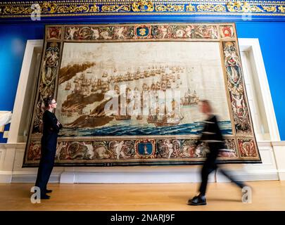 (Von links nach rechts) die Kuratoren Allison Goudie und Imogen Tedbury vom Queen's House beobachten den Solebay Tapestry, nachdem er in der Anwesenheitskammer des Königs im Queen's House in Greenwich, Süd-London, installiert wurde. Der Wandteppich ist das Hauptobjekt der bevorstehenden Ausstellung, The Van de Veldes: Greenwich, Art and the Sea. Foto: Montag, 13. Februar 2023. Stockfoto