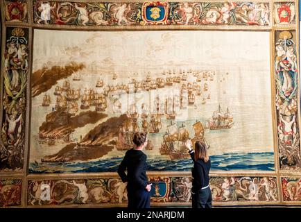 (Von links nach rechts) die Kuratoren Allison Goudie und Imogen Tedbury vom Queen's House beobachten den Solebay Tapestry, nachdem er in der Anwesenheitskammer des Königs im Queen's House in Greenwich, Süd-London, installiert wurde. Der Wandteppich ist das Hauptobjekt der bevorstehenden Ausstellung, The Van de Veldes: Greenwich, Art and the Sea. Foto: Montag, 13. Februar 2023. Stockfoto