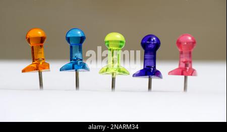 Viele farbenfrohe Stecknadeln auf weißem Farbkonzept. Stockfoto