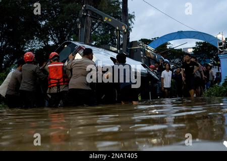 Makassar, Indonesien. 13. Februar 2023. Nach heftigem Regen in Makassar, Süd-Sulawesi, Indonesien, am 13. Februar 2023 versucht man, ein Auto zu evakuieren, das von Überschwemmungen überschwemmt wurde. Kredit: Niaz Sharief/Xinhua/Alamy Live News Stockfoto