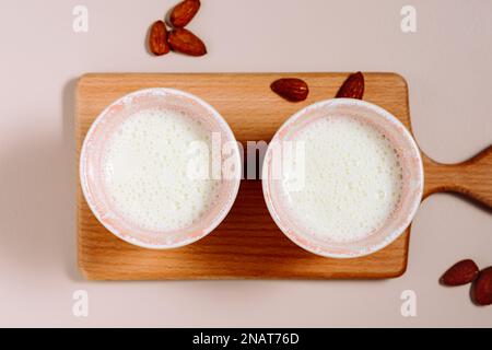 Vegane Pflanzenmilch auf pinkfarbenem Hintergrund. Stockfoto