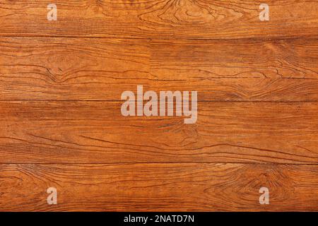 Orangefarbene Holzbretter passen eng aneinander und haben eine verarbeitete Struktur aus Fasern und Knoten. Stockfoto