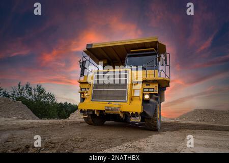 Ein großer Steinbruch-Müllwagen in einem Kohlebergwerk. Kohle in Muldenkipper laden. Bergbauausrüstung für den Transport von Mineralien. Stockfoto