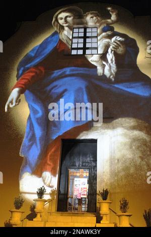 Gaeta, Italien. Eine künstlerische Projektion der Jungfrau Maria mit Jesuskind an der Fassade der Kirche S. Maria di Porto Salvo während der Weihnachtszeit. Stockfoto