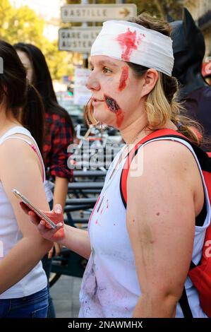 PARIS, FRANKREICH - 3. OKTOBER 2015: Junge "verwundete" Zombie-Frau mit Handy in der Hand während der Zombie-Parade am Place de la Republique. Zombie Wal Stockfoto