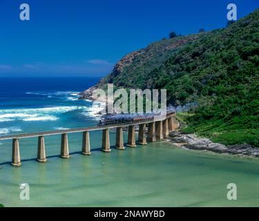 DIE DAMPFEISENBAHN OUTENIQUA CHOO TJOE ÜBERQUERT DIE KAAIMANS RIVER GARDEN ROUTE SÜDAFRIKA Stockfoto