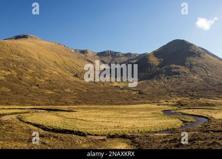 Blick über die mit Heidekraut bedeckten Berge von Glen Shiel im schottischen Hochland mit dem Fluss Cluanie im Vordergrund Stockfoto