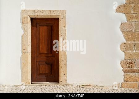 Hölzerne Tür in eine weiße Wand Stockfoto