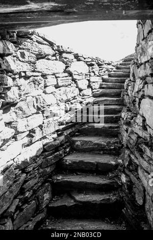 Die schmale innere Treppe der Ruine einer alten Brosche der schottischen Highlands in Schwarz und Weiß Stockfoto