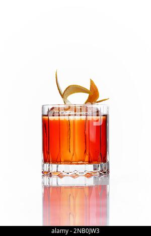 Orangefarbener alkoholischer Cocktail in einem altmodischen Glas auf weißem Hintergrund Stockfoto