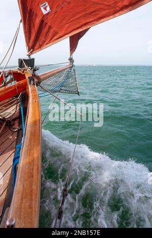 An Bord des traditionellen Spafenschneiders „Jolie Brise“, während sie über Solent, Hampshire, Großbritannien reicht und eine feine Bogenwelle erzeugt Stockfoto