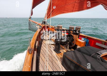 An Bord des traditionellen Spafenschneiders „Jolie Brise“, während sie über Solent, Hampshire, Großbritannien reicht und eine feine Bogenwelle erzeugt Stockfoto