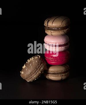 Bunte Makronen. Jeder zarte Bissen bietet eine Sinfonie an Geschmacksrichtungen und Texturen, die Ihren Gaumen verwöhnen und Ihnen das Verlangen nach mehr wecken werden. Stockfoto