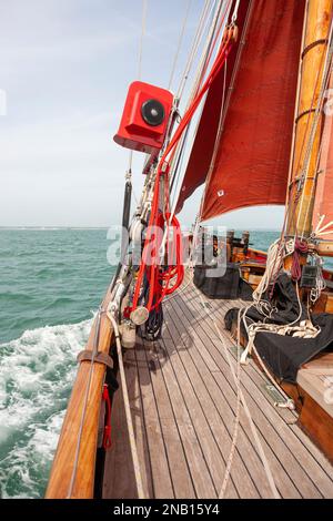 An Bord des traditionellen Spafenschneiders „Jolie Brise“, während sie über Solent, Hampshire, Großbritannien reicht und eine feine Bogenwelle erzeugt Stockfoto