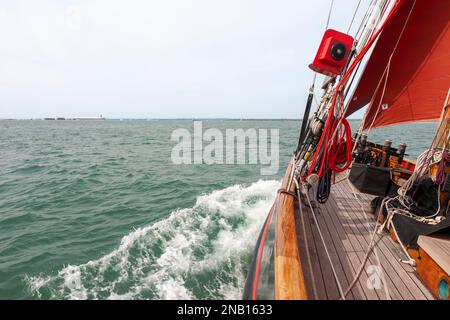 An Bord des traditionellen Spafenschneiders „Jolie Brise“, während sie über Solent, Hampshire, Großbritannien reicht und eine feine Bogenwelle erzeugt Stockfoto