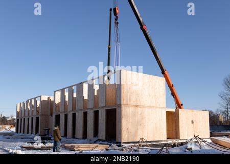 Der Bau eines neuen und modernen modularen Hauses aus Verbundplatten an einem sonnigen Wintertag. Stockfoto