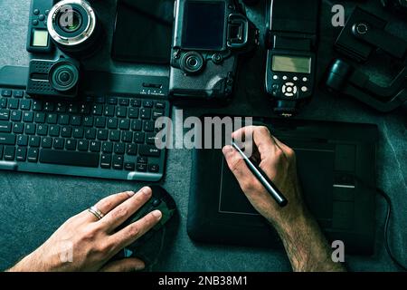 Digitale Foto-Workstation mit schwarzem Hintergrund. Draufsicht von Digitalkamera, Blitz, Objektiv und Laptop. Professionelle Fotoausrüstung. Stockfoto