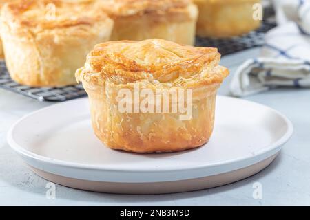 Kleine Rindfleischpastete auf einem Teller und einem Kühlregal, horizontal Stockfoto