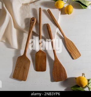 Holzspatel mit Zitronen auf weißem Tisch Stockfoto
