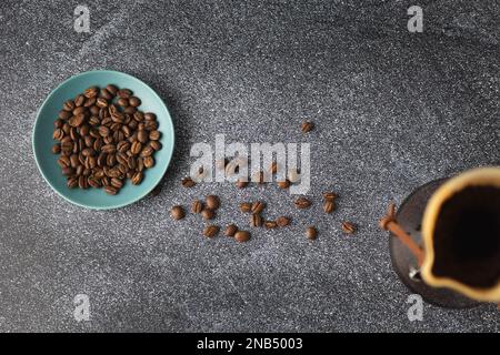 Zubereitung von Pour-Over-Kaffee in einem Glasbehälter auf einer Arbeitsfläche aus sauberem Stein mit weißem Marmorblitz Stockfoto
