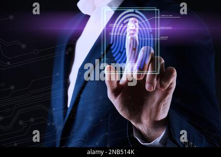 Mann mit biometrischem Fingerabdruck-Scanner auf dunklem Hintergrund, Nahaufnahme Stockfoto