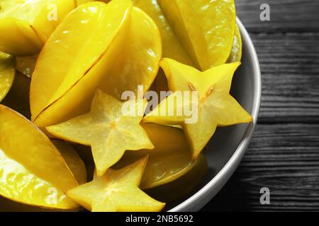 Köstliche Karambola-Früchte auf schwarzem Holztisch, Nahaufnahme Stockfoto