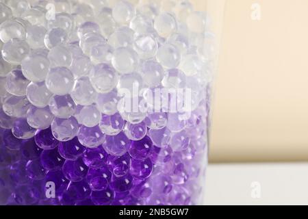 Füllstoffe in verschiedenen Farben in Glasvase, Nahaufnahme. Wasserperlen Stockfoto