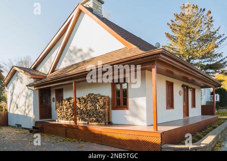 Alte Fassade im französischen Stil aus dem Jahr 1877 mit weißem Stuck, rötlich-braunen gebeizten Gitterarbeiten und Holzfenstern mit Stilreproduktion. Stockfoto