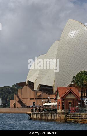 483 Seitenansicht des Sydney Opera House Podiums und einige Muscheldächer mit einem malerischen roten Backsteingebäude aus den frühen 1900er Jahren im Vordergrund. NSW-Australien. Stockfoto