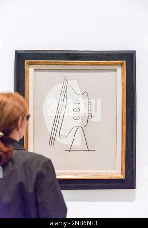 Eine Frau schaut sich ein Gemälde von Pablo Picasso mit dem Titel Figur (1928) im Reina Sofia Museum in Madrid an, Spanien mit Kopie von Raumöl Stockfoto