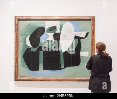 Eine Frau schaut sich im Reina Sofia Museum in Madrid, Spanien, ein Pablo Picasso Gemälde mit dem Titel „Musikinstrumente auf einem Tisch“ (1924) an Stockfoto