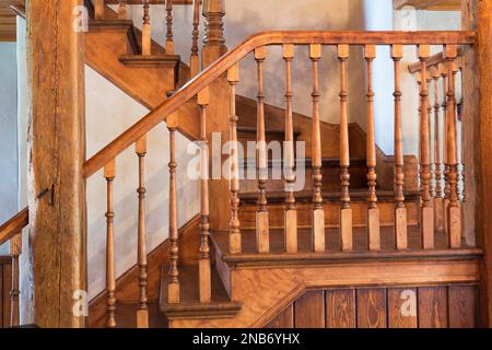 Kirschholztreppe führt in die obere Etage in ein altes 1826 Landhaus im Feldsteinhaus im Landhausstil. Stockfoto