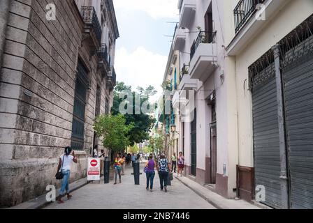 Eine Straßenszene in der Innenstadt im alten Teil der Innenstadt von Havanna Kuba mit Touristen und Einheimischen, die die restaurierten kolonialen Gebäude und engen Gassen bewundern. Stockfoto